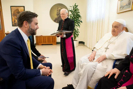USAs visepresident J.D. Vance sitter i en stol og hilser på pave Frans, som også sitter i en stol