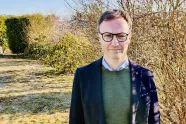 Portrett av diakon Sigurd Hareide utendørs i have. 