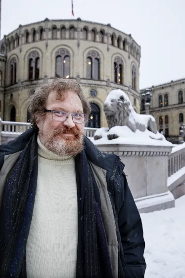 Kaare Seeberg Sidselrud, mann med skjegg, foran Stortinget