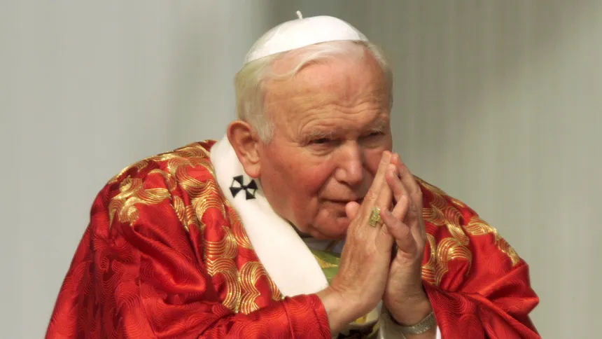 Pave Johannes Paul II, ikledd røde messeklær, ber