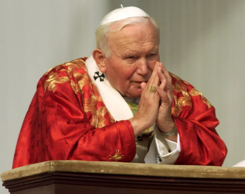 Pave Johannes Paul II, ikledd røde messeklær, ber