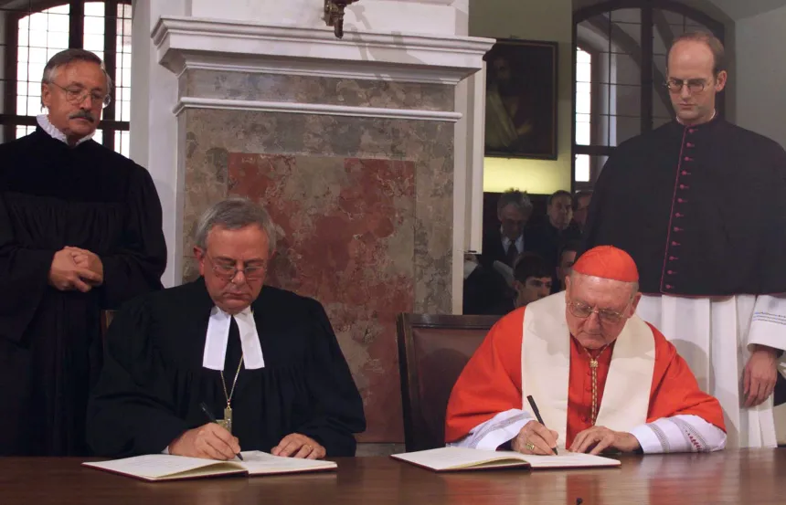 En luthersk biskop og en katolsk kardinal signerer et dokument