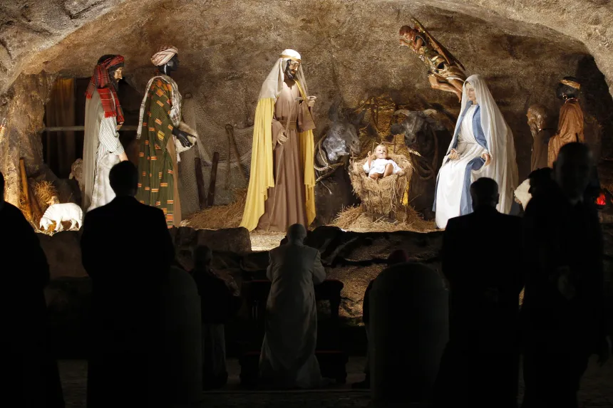 Pave Benedikt XVI ber foran en julekrybbe med figurer
