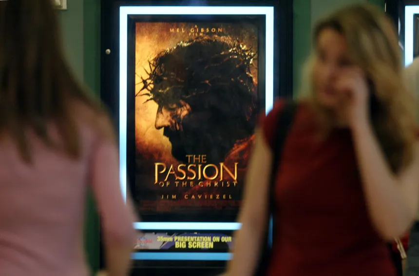 Kvinne går forbi plakat for filmen The Passion of the Christ