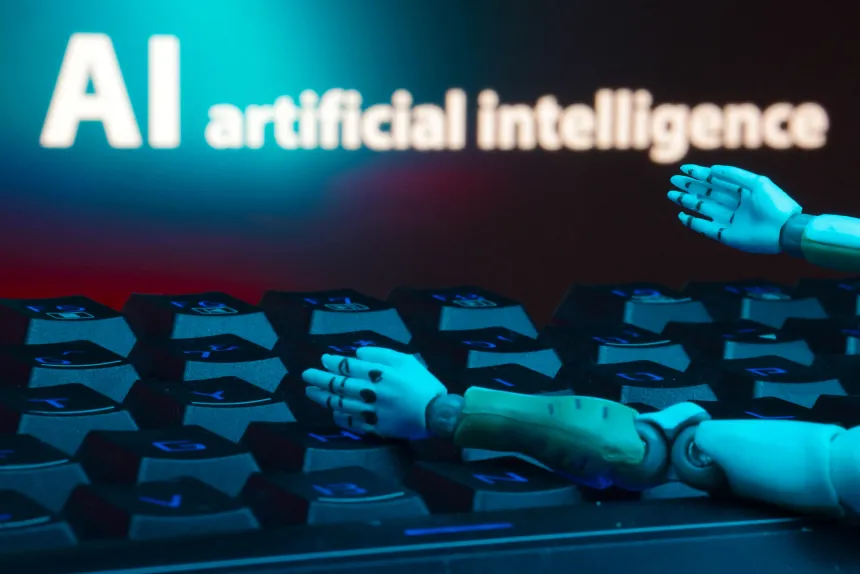 To robothender på et tastatur under teksten "AI artificial intelligence"
